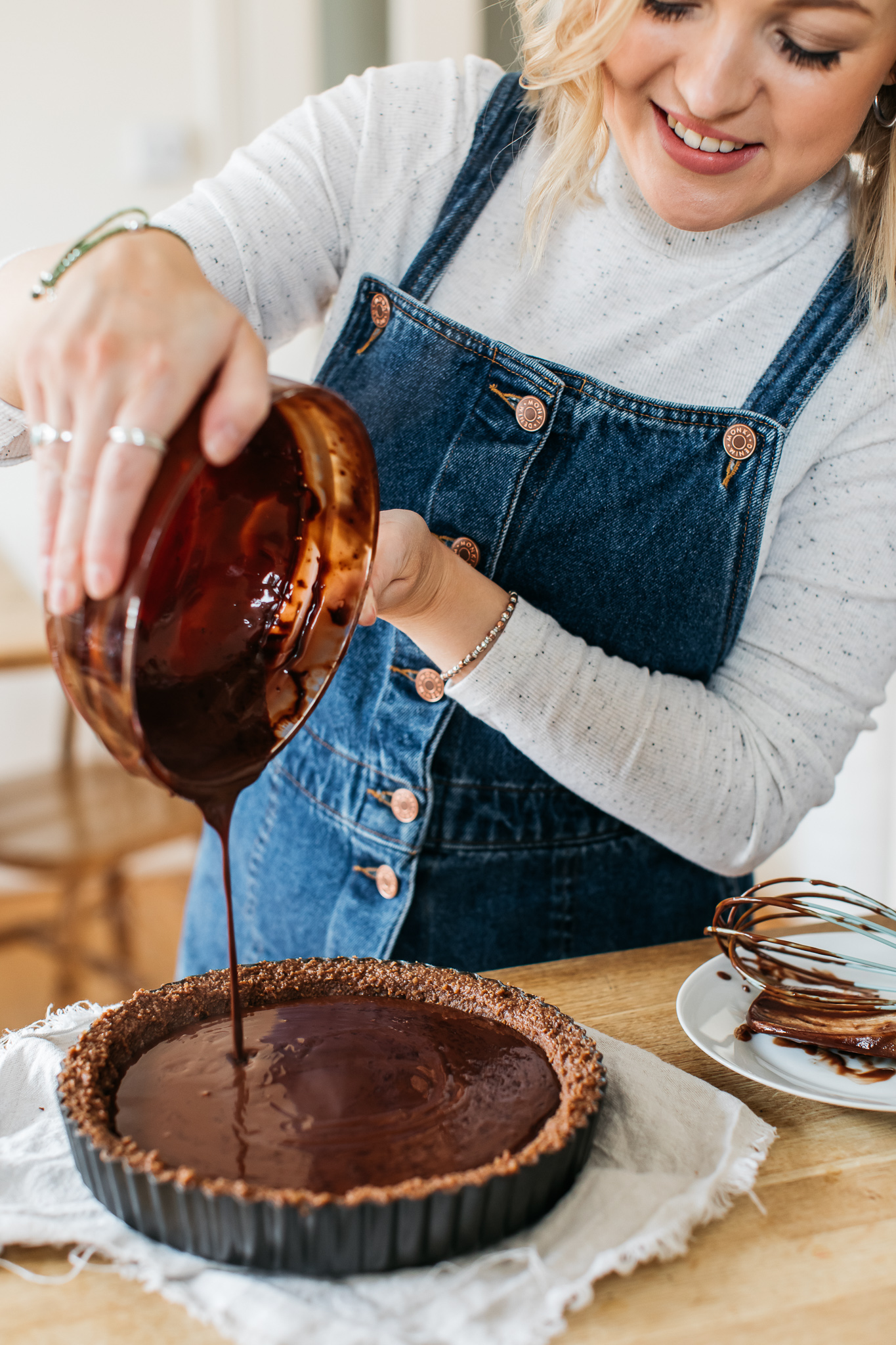 Pouring chocolate into gluten free tart case
