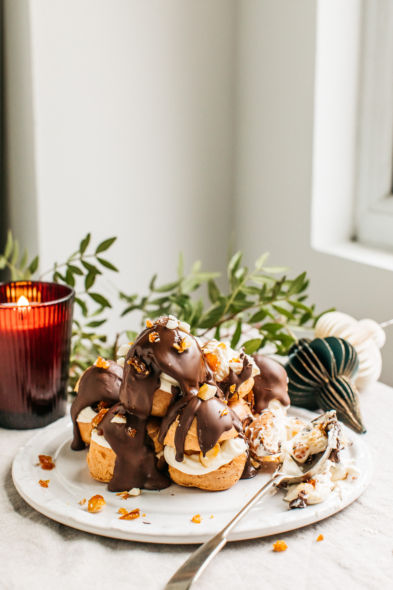 Gluten-free profiteroles covered in chocolate with a spoonful eaten