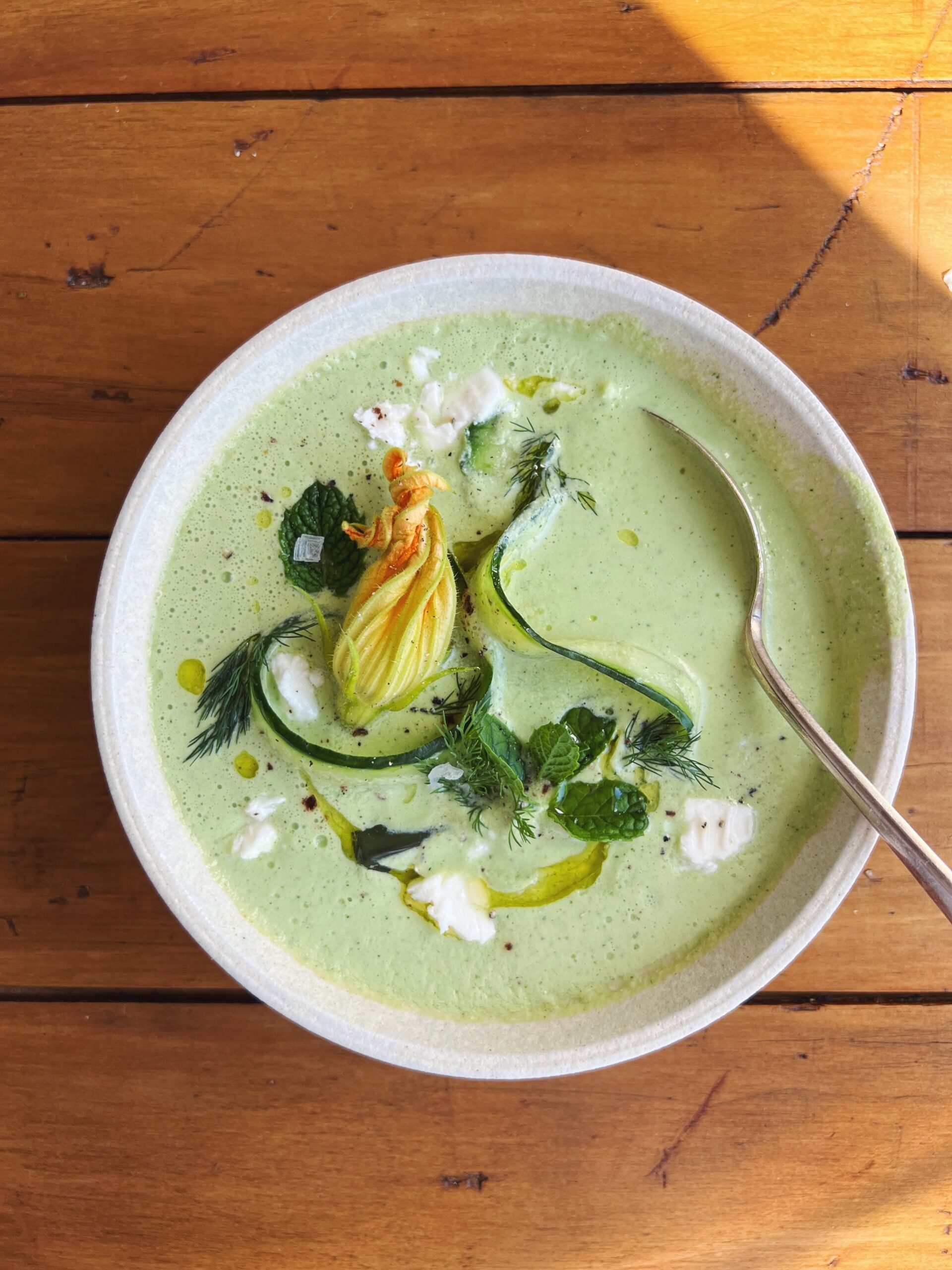 Spoon in a bowl of low FODMAP summer soup chilled cucumber and yogurt