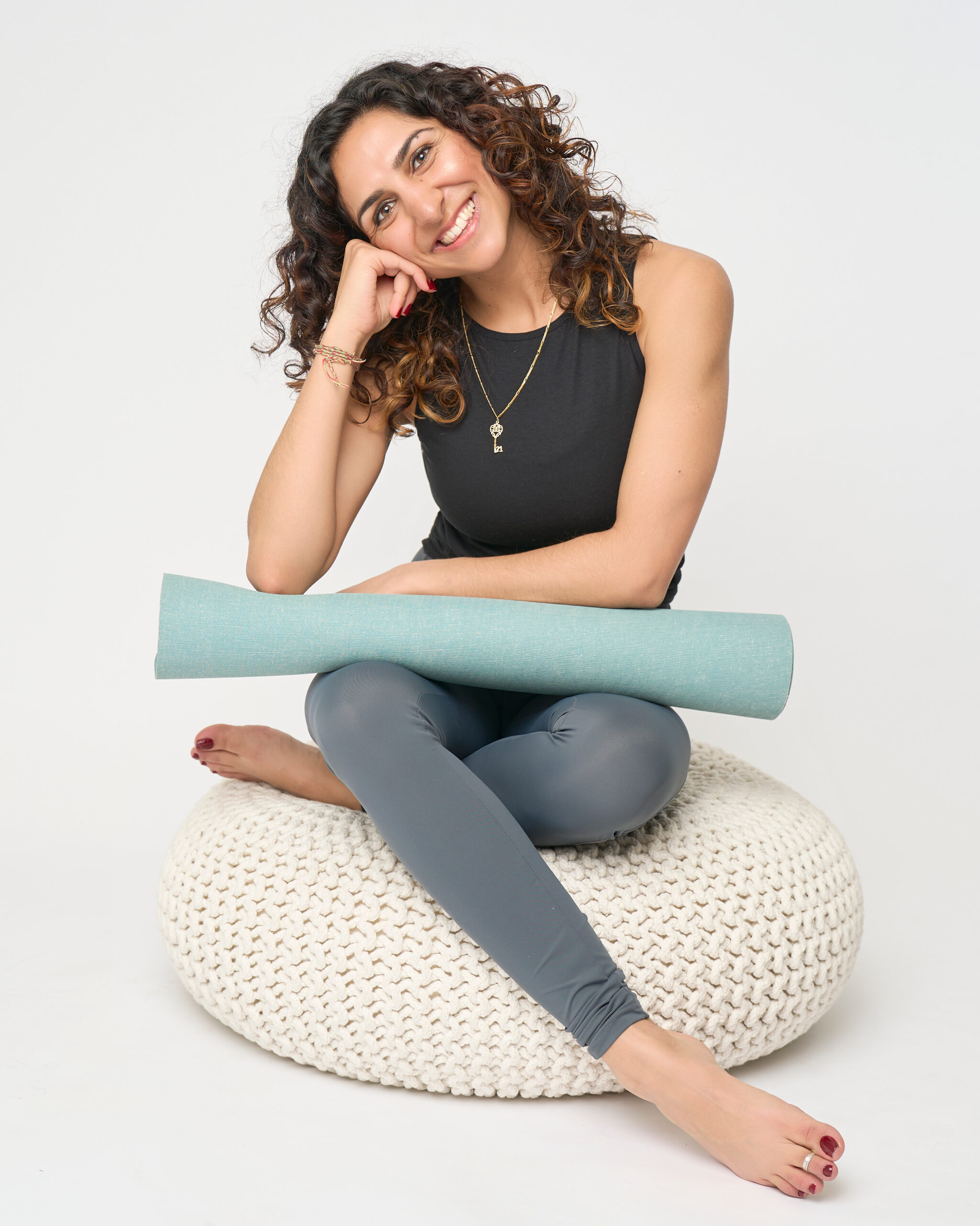 Dr Rabia sat on stool with yoga mat