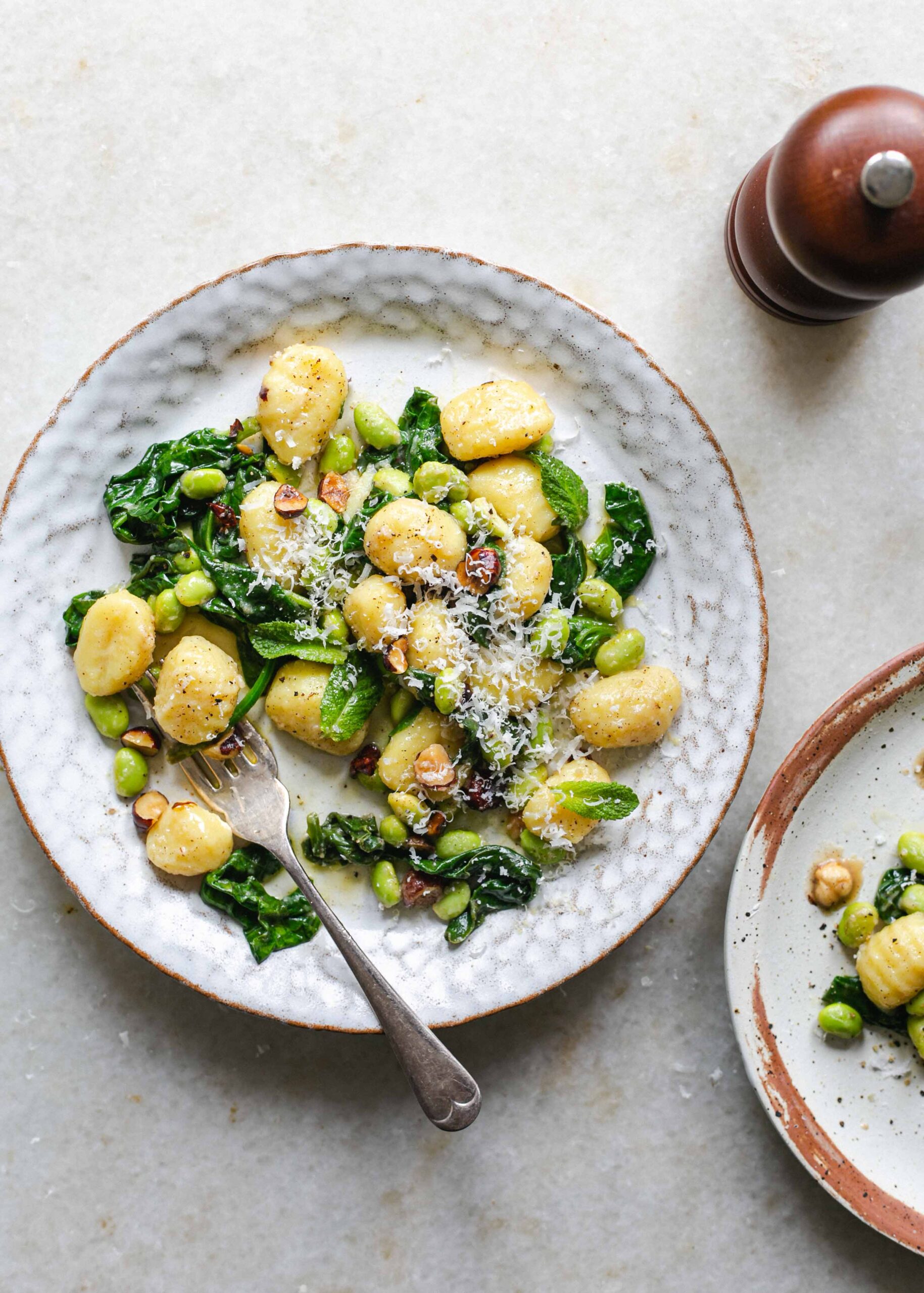 A plate of gluten free gnocchi with brown butter and spinach and grated cheese